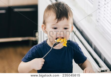 A Child In The Kitchen Eats Eggs Or Omelets In The Afternoon