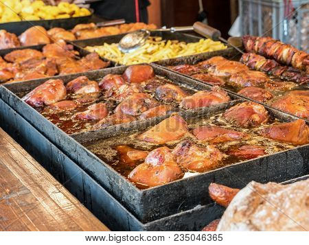 Roasting pan full of red meat chops, shish kabobs and sausages ready for barbecue