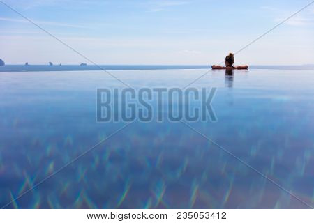 Rear View Of Woman Resting In Infinity Pool At A Aonang Beach Resort Thailand Asia