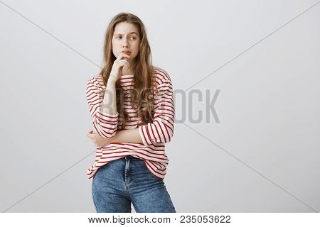 Girl Is Thinking How To Skip Classes. Portrait Of Charming Blonde Teenager In Cute Striped Sweater H
