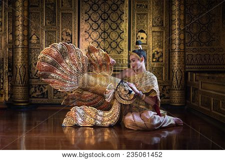 Beautiful Women In Tradition Antique Thai Pattern Dress Sit Near Gold Fish  Statuary.