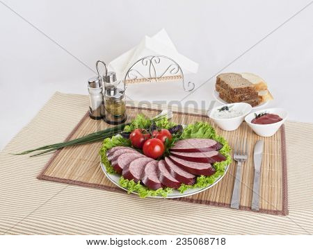Smoked Sausage With Tomatoes And Lettuce Leaves On A Plate.  Can Be Used In Advertising And In The D