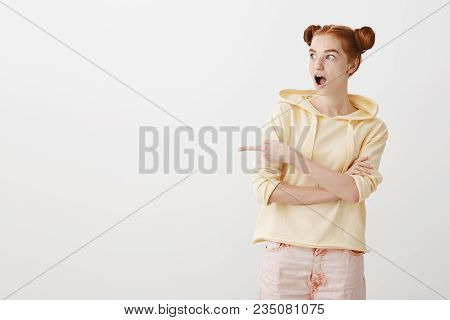 What An Amazing Show In That Direction. Portrait Of Surprised Thrilled Young Redhead Woman With Two 