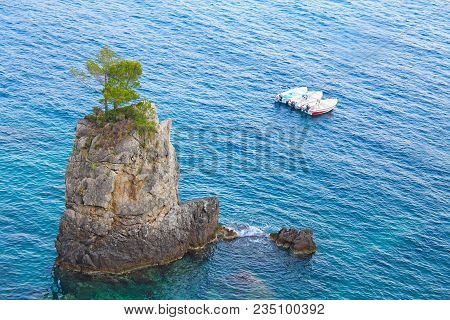 Photo Made In Greece On The Island Of Corfu. Rock In The Sea And Boats At Anchor