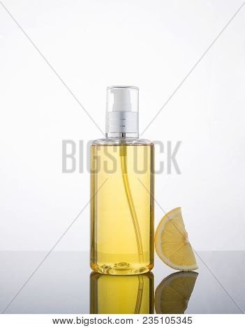 High Key Photography Liquid Jel Bottle And Lemon With Droplet In The Background.