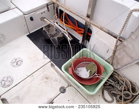 The science equipment: benthic grab sampler, square basin and sieve on the boat