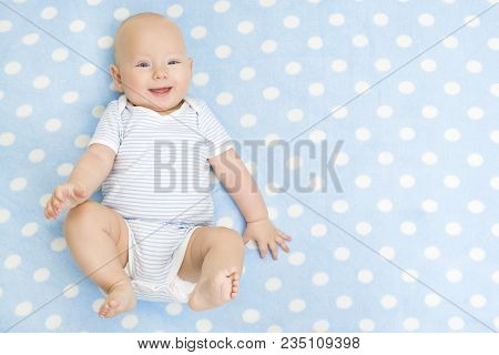Happy Baby Lying On Blue Carpet Background, Top View, Smiling Infant Kid Boy Dressed In Bodysuit On 