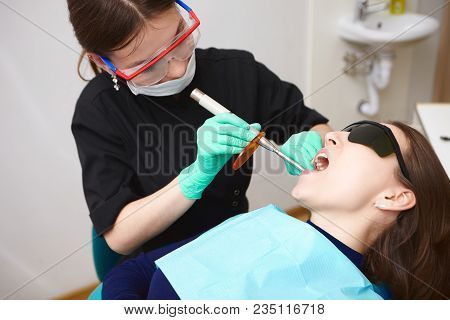 Polymerization Of Light Cure Resin Based Composites. Experienced Professional Young Brunette Woman D