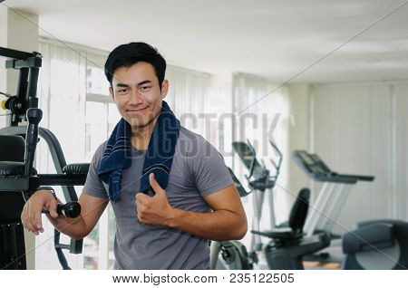 Muscular Asian Young Handsome Man With Towel Showing Thumbs Up While Resting After Workout In Fitnes