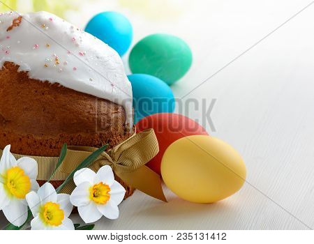 Homemade Easter Cake And Easter Eggs On White Wooden Table. Easter Background With Spring Daffodil F