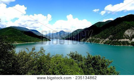 A Beautiful View Of The Lake, Nice Color, Surrounded By Mountains In The Background Of A Beautiful S