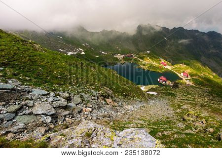 Area Of Lake Balea In Clouds. Gorgeous Summer Landscape Of Fagarasan Mountains, Romania. Popular Tou