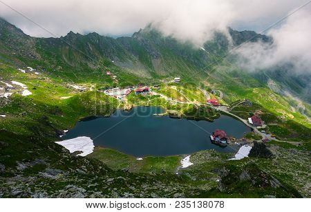 Area Of Lake Balea In Clouds. Gorgeous Summer Landscape Of Fagarasan Mountains, Romania. Popular Tou