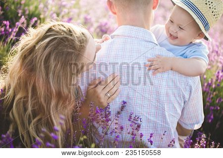 Mom, Dad And Their Little Son Are Walking In A Lavender Field. Life In Provence