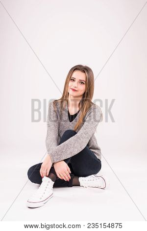 Attractive Teenage Girl Sitting On The Floor. All On White Background.