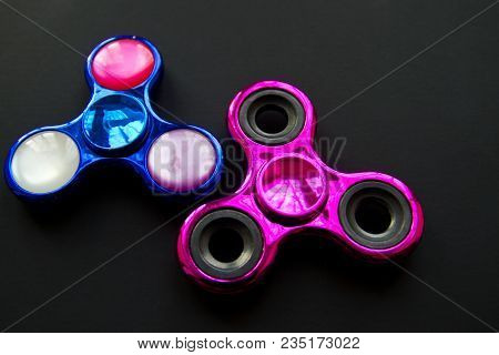 Fidget Finger Metal Spinner, Anxiety Relief Toy On Black Background, Copyspace. Concept Relieving St