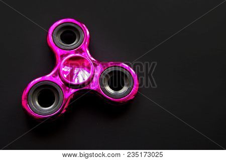 Fidget Finger Metal Spinner, Anxiety Relief Toy On Black Background, Copyspace. Concept Relieving St