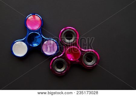 Fidget Finger Metal Spinner, Anxiety Relief Toy On Black Background, Copyspace. Concept Relieving St