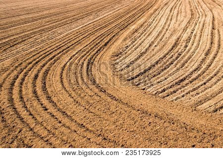 Pre-food Production And A Plowed Field: Brown Dirt Field Tilled In An Interesting Pattern Of Straigh