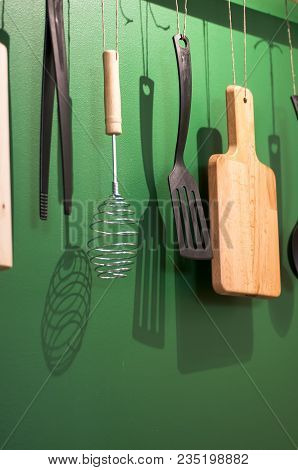 Different Kitchen Tools For Cooking Hanging On The Wall