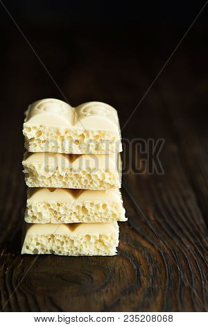 Pyramid Of White Porous Chocolate On A Wooden Vintage Old Background In The Style Of Moodle