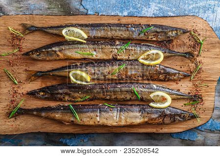 Smoked Oceanic Saury On Wooden Cutting Board, Top View, Copy Space.