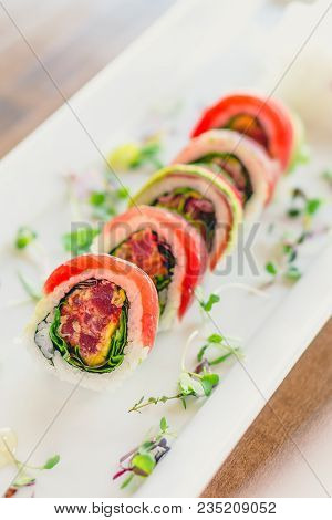 Japanese Uramaki Sushi Roll. A Uramaki Style Sushi Roll On A White Plate. The Raw Sashimi Tuna Fish 