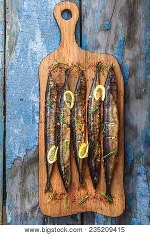Smoked Oceanic Saury On Wooden Cutting Board, Top View, Copy Space.