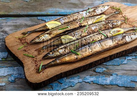 Smoked Oceanic Saury On Wooden Cutting Board, Top View, Copy Space.