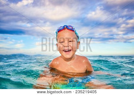 Cute boy plays in a sea