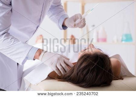 Police coroner examining dead body corpse in morgue