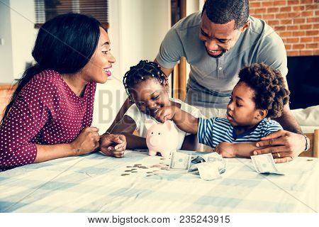 Family saving money to piggy bank