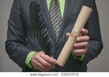 Businessman Holds In Hand A Rolled Up Document Scroll And Feather Pen. Signing Of An Agreement. Conc