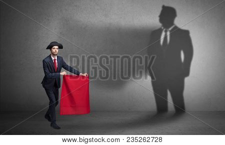 Businessman standing with red cloth on his hand and his shadow on the background