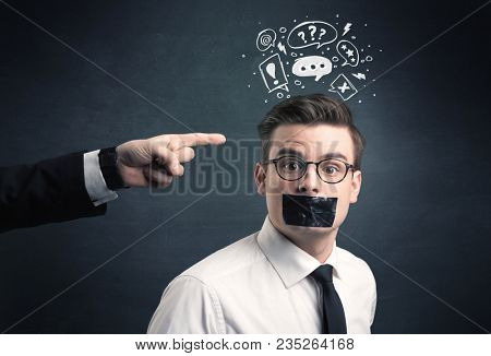 Caucasian business hand pointing at stressed male employee with drawn question, explamation marks, talk bubble above his head