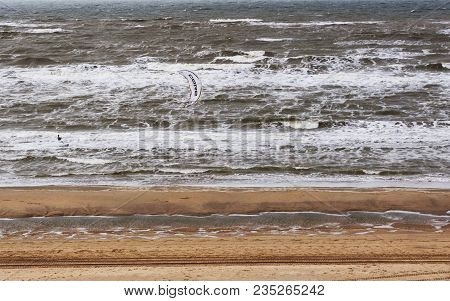 Netherlands, April 2017: The Windy Cold Sand Beach On The North Of The Europe. There Is A Small Figu