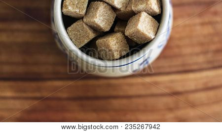 Photography With Kitchen Theme: Still Life With Brown Lump Sugar In Ceramic Bowl On Wooden Cutting B
