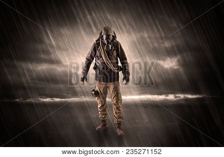 Terrorist in a stormy space with gas mask on his hand and weapons on his arm