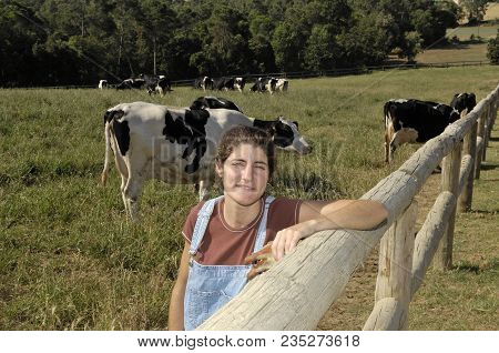 Portrait Of A Farmer With Her Cows In The Field