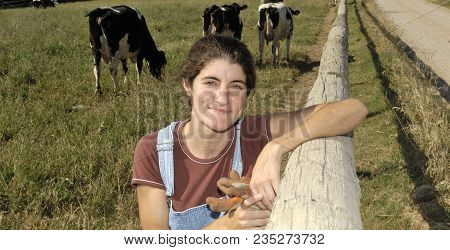 Portrait Of A Farmer With Her Cows In The Field