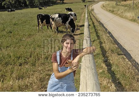 Portrait Of A Farmer With Her Cows In The Field