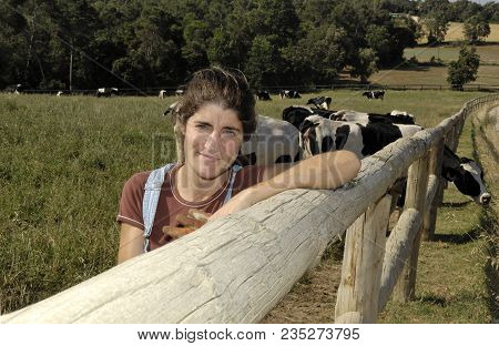 Portrait Of A Farmer With Her Cows In The Field