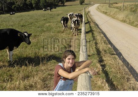 Portrait Of A Farmer With Her Cows In The Field