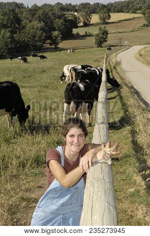 Portrait Of A Farmer With Her Cows In The Field
