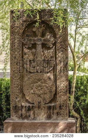 Medieval Stone Cross Under The Willow Tree In The Garden Of The Church Of St. Mesrop Mashtots In The