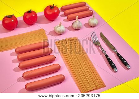A Lot Of Raw Sausages With Pasta And Vegetables On Pink And Yellow Background, Top View. Still Life.