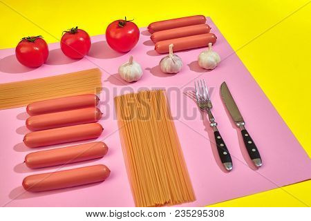 A Lot Of Raw Sausages With Pasta And Vegetables On Pink And Yellow Background, Top View. Still Life.