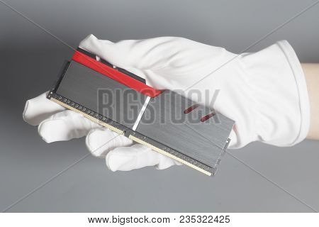 Hand In White Glove Holding High Performance Ddr4 Computer Memory Ram On Gray