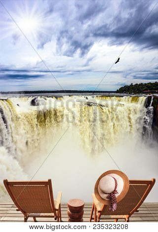 Devil's Throat is the most grandiose part of the Iguazu Falls. Concept of active and photographic tourism. Two wooden comfortable chaise longue stand near the picturesque waterfalls