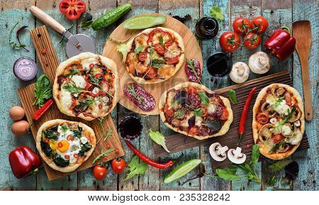 Flatlay Of Freshly Prerared Delicious Italian Style Pizzas. Five Pizzas With Eggs, Salami, Mushrooms